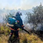 рятувальник гасить пожежу сухої трави
