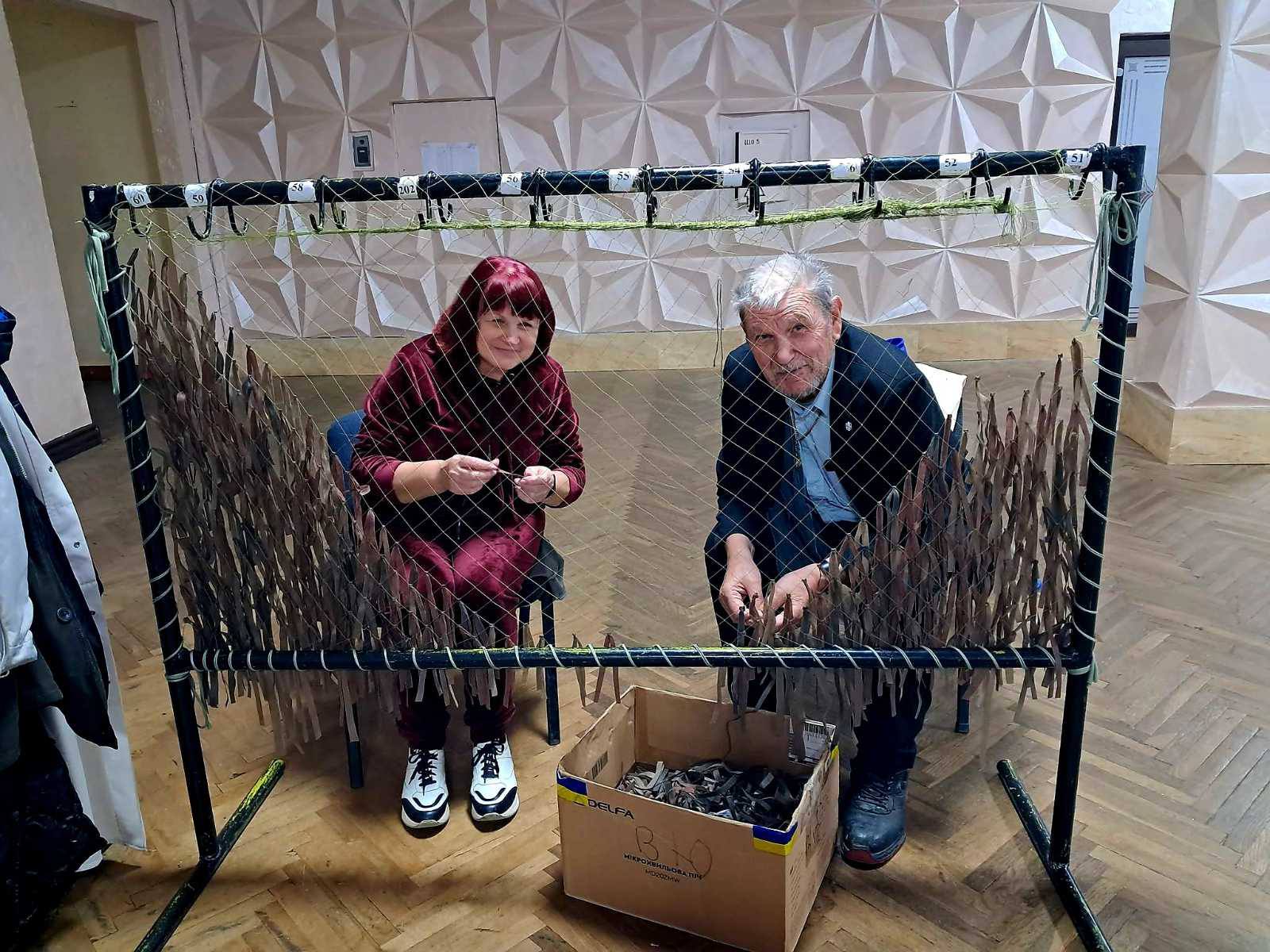 У Калуші родини Героїв та соцпрацівники плетуть маскувальні сітки для захисників (ФОТО)